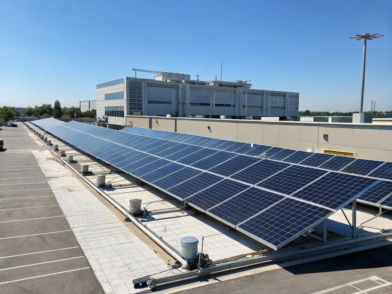 An image of solar panels installed on a commercial building roof with clear sky background, promoting sustainable and renewable power generation.